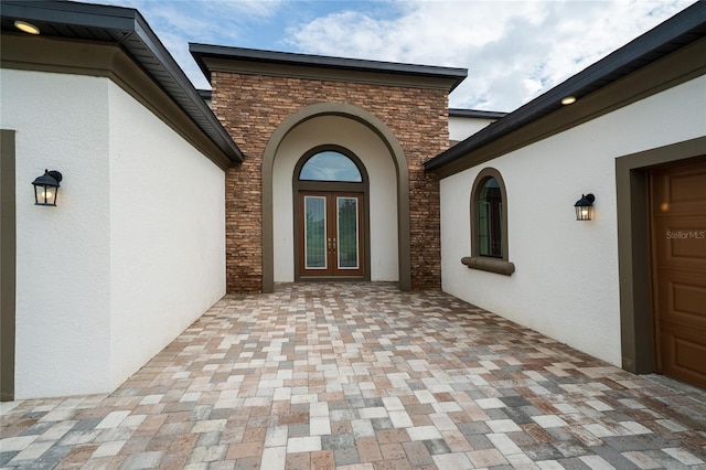8834 Sanders Tree Loop, Wesley Chapel, FL 33545 - entrance to property featuring french doors, stone siding, stucco siding, and a garage