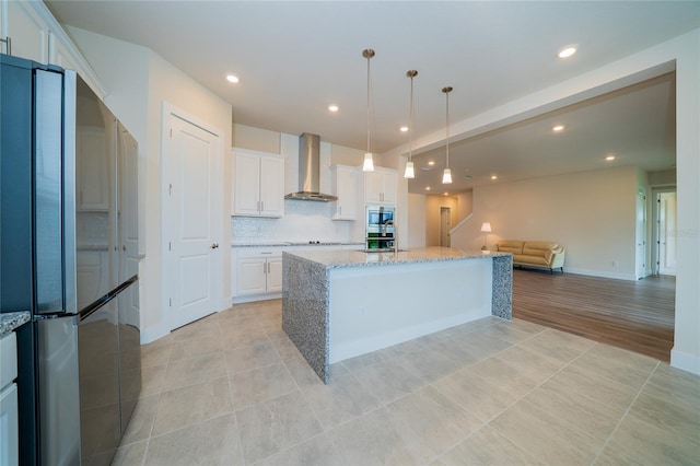 8834 Sanders Tree Loop, Wesley Chapel, FL 33545 - kitchen with appliances with stainless steel finishes, wall chimney range hood, open floor plan, white cabinets, and recessed lighting