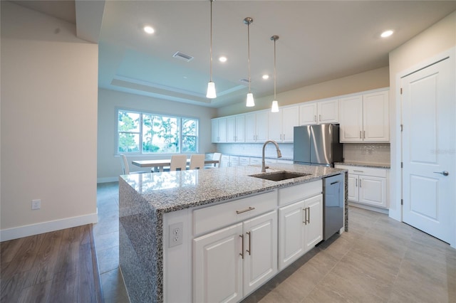 8834 Sanders Tree Loop, Wesley Chapel, FL 33545 - kitchen with appliances with stainless steel finishes, a sink, an island with sink, white cabinetry, and light stone counters
