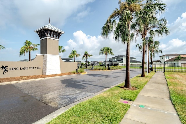 8834 Sanders Tree Loop, Wesley Chapel, FL 33545 - view of asphalt street featuring sidewalks, curbs, a residential view, street lights, and a gated entry