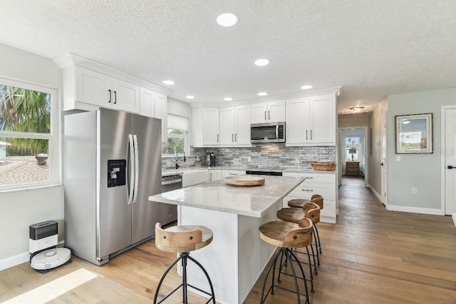 3285 Minnow Creek Dr, Hernando Beach, FL 34607 - kitchen with appliances with stainless steel finishes, a textured ceiling, baseboards, light wood-style floors, and recessed lighting