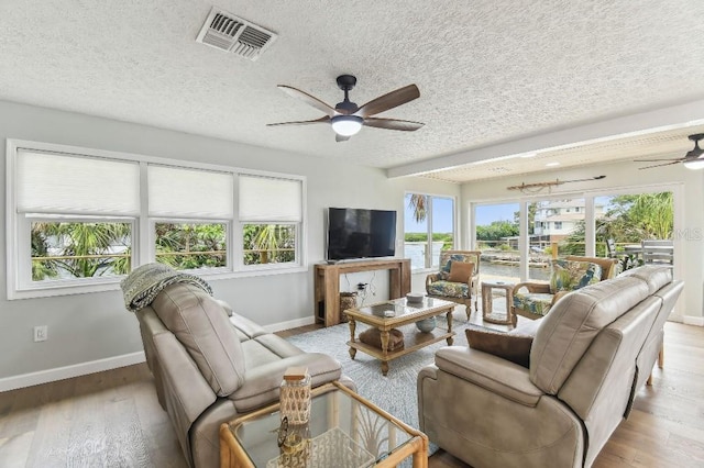 3285 Minnow Creek Dr, Hernando Beach, FL 34607 - living area featuring a ceiling fan, baseboards, plenty of natural light, a textured ceiling, and wood finished floors