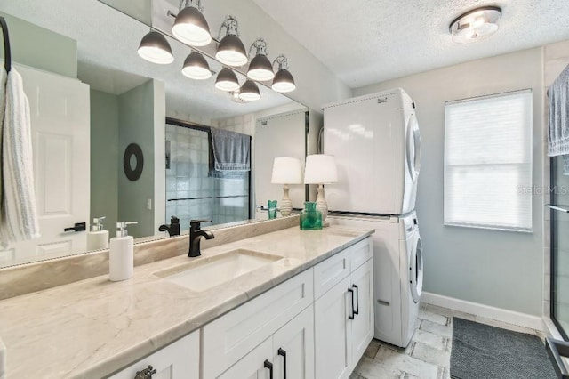 3285 Minnow Creek Dr, Hernando Beach, FL 34607 - full bath with estacked washer and dryer, vanity, a textured ceiling, a shower stall, and baseboards