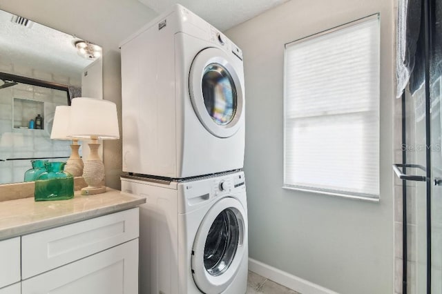 3285 Minnow Creek Dr, Hernando Beach, FL 34607 - laundry area featuring stacked washer and clothes dryer, baseboards, and light tile patterned flooring