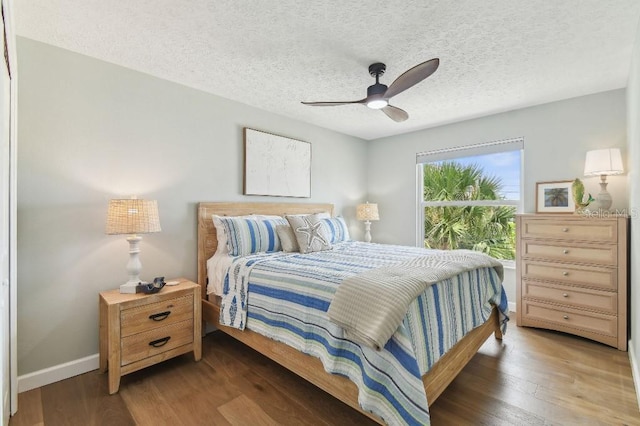 3285 Minnow Creek Dr, Hernando Beach, FL 34607 - bedroom featuring wood finished floors, baseboards, a textured ceiling, and ceiling fan