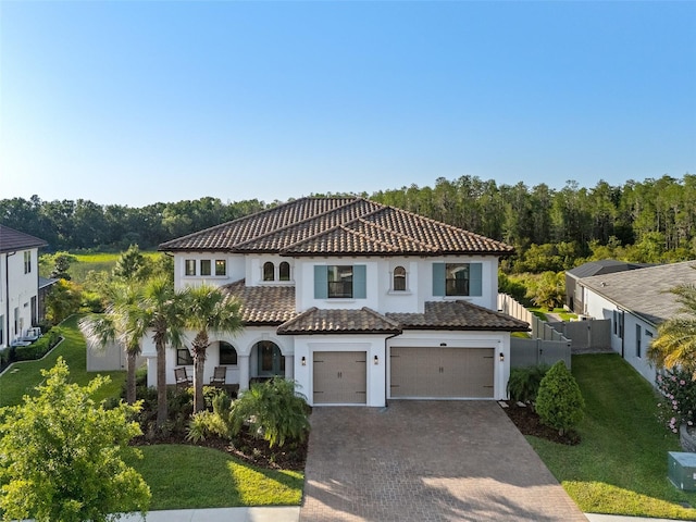 28512 Picana Ln, Wesley Chapel, FL 33543 - mediterranean / spanish home featuring a garage, stucco siding, a tile roof, and decorative driveway