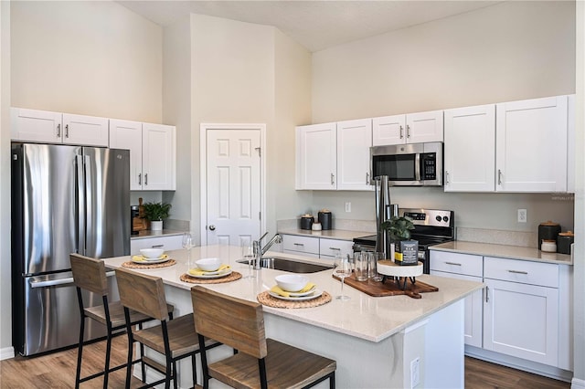 1716 Vanilla St, Haines City, FL 33844 - kitchen with appliances with stainless steel finishes, a sink, high vaulted ceiling, dark wood-style flooring, and white cabinets