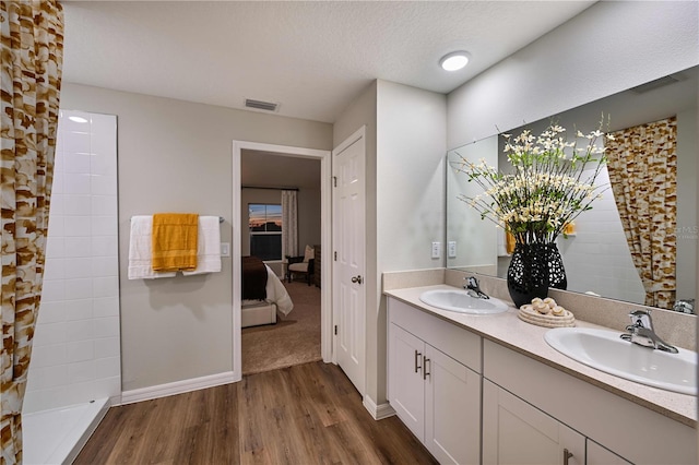 1716 Vanilla St, Haines City, FL 33844 - ensuite bathroom featuring wood finished floors, double vanity, baseboards, and a tile shower