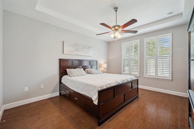 11314 American Holly Dr, Riverview, FL 33578 - bedroom featuring baseboards, dark wood-style flooring, a raised ceiling, and a ceiling fan