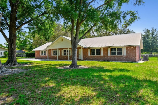 17801 Simmons Rd, Lutz, FL 33548 - ranch-style home featuring central AC unit, brick siding, and metal roof