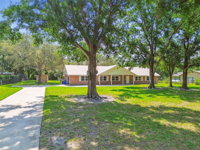 17801 Simmons Rd, Lutz, FL 33548 - ranch-style house with driveway, a front lawn, and brick siding