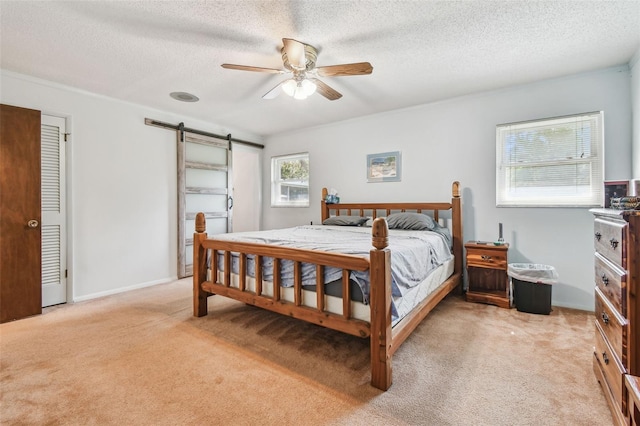 17801 Simmons Rd, Lutz, FL 33548 - bedroom featuring a barn door, light carpet, a textured ceiling, a ceiling fan, and baseboards