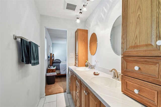 17801 Simmons Rd, Lutz, FL 33548 - full bath featuring double vanity, connected bathroom, tile patterned floors, and baseboards