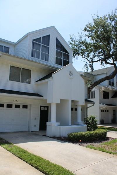 9722 Indian Key Trl Unit 116, Seminole, FL 33776 - view of front of home with an attached garage and driveway