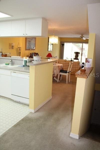 9722 Indian Key Trl Unit 116, Seminole, FL 33776 - kitchen with light carpet, white cabinets, dishwasher, light countertops, and pendant lighting