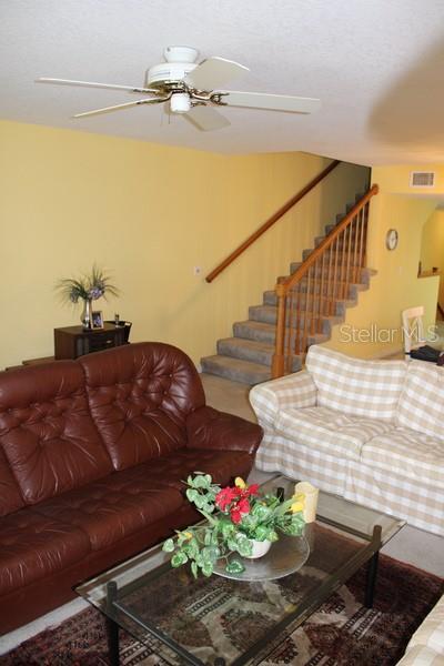 9722 Indian Key Trl Unit 116, Seminole, FL 33776 - living area featuring stairs and ceiling fan