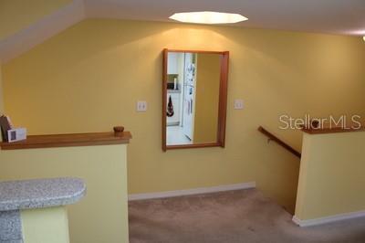 9722 Indian Key Trl Unit 116, Seminole, FL 33776 - staircase with lofted ceiling and carpet floors