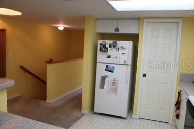 9722 Indian Key Trl Unit 116, Seminole, FL 33776 - kitchen featuring freestanding refrigerator, light colored carpet, and baseboards