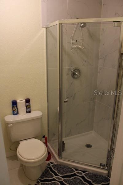 9722 Indian Key Trl Unit 116, Seminole, FL 33776 - full bath with a shower stall, toilet, and tile patterned floors