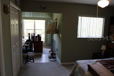 9722 Indian Key Trl Unit 116, Seminole, FL 33776 - bedroom featuring carpet flooring, a desk, and baseboards