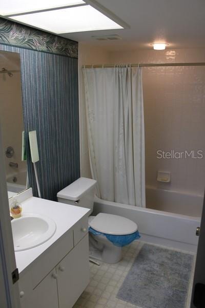 9722 Indian Key Trl Unit 116, Seminole, FL 33776 - full bath featuring shower / tub combo, vanity, tile patterned floors, toilet, and wallpapered walls