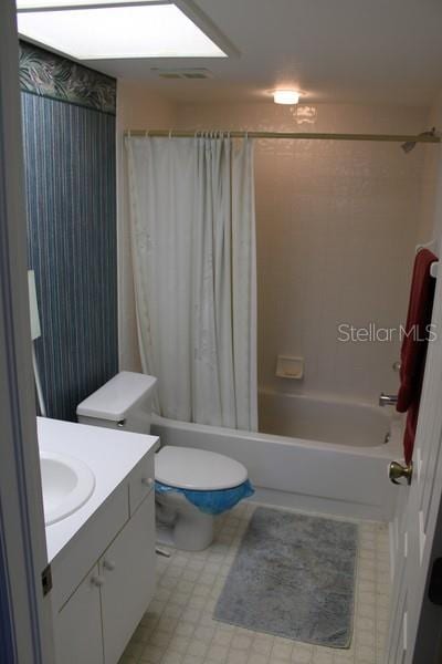 9722 Indian Key Trl Unit 116, Seminole, FL 33776 - full bathroom with shower / bathtub combination with curtain, vanity, toilet, and tile patterned floors