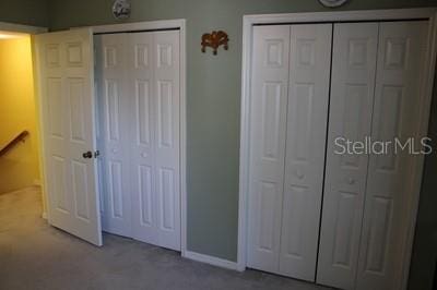 9722 Indian Key Trl Unit 116, Seminole, FL 33776 - unfurnished bedroom with multiple closets, carpet, and baseboards
