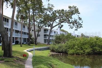 9722 Indian Key Trl Unit 116, Seminole, FL 33776 - view of property's community with a water view and a lawn