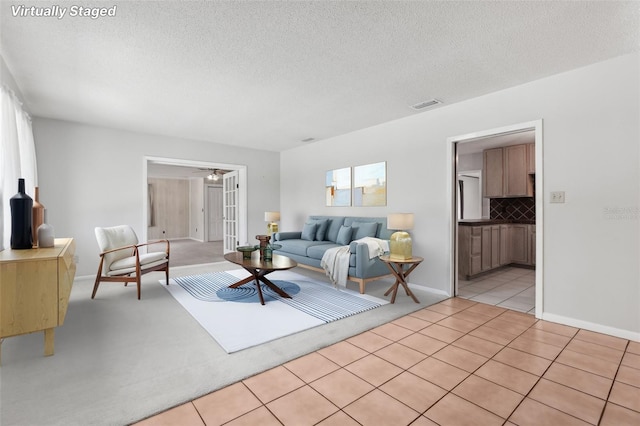 1212 Blake Ave, Auburndale, FL 33823 - living area featuring light tile patterned flooring, a textured ceiling, ceiling fan, and baseboards