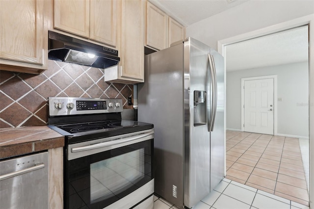 1212 Blake Ave, Auburndale, FL 33823 - kitchen with stainless steel appliances, under cabinet range hood, light brown cabinets, and backsplash