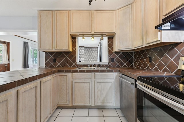 1212 Blake Ave, Auburndale, FL 33823 - kitchen featuring stainless steel appliances, range hood, a sink, tile counters, and light brown cabinetry