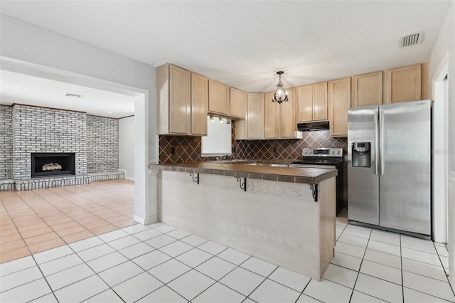 1212 Blake Ave, Auburndale, FL 33823 - kitchen featuring stainless steel appliances, under cabinet range hood, light brown cabinetry, and decorative backsplash
