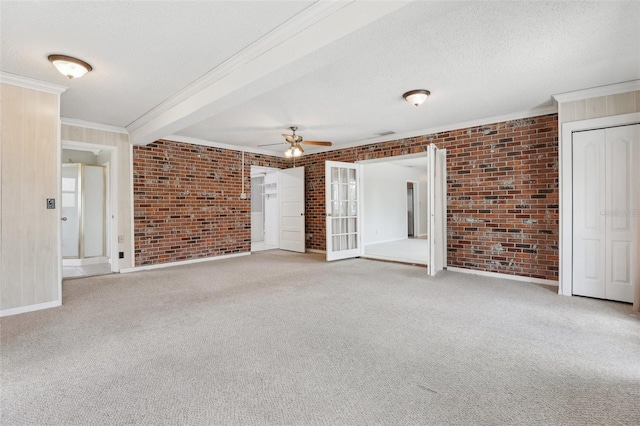 1212 Blake Ave, Auburndale, FL 33823 - empty room with brick wall, ornamental molding, a ceiling fan, a textured ceiling, and carpet floors