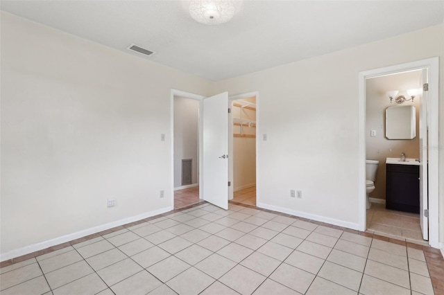 1212 Blake Ave, Auburndale, FL 33823 - unfurnished bedroom with a sink, a spacious closet, baseboards, and light tile patterned flooring