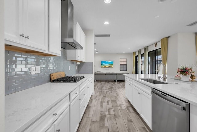 12650 Shetland Walk Dr, Lithia, FL 33547 - kitchen featuring appliances with stainless steel finishes, wall chimney range hood, a sink, open floor plan, and white cabinetry