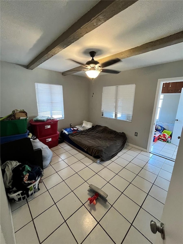 1708 28th St W, Bradenton, FL 34205 - bedroom featuring light tile patterned flooring, beamed ceiling, a textured ceiling, ceiling fan, and baseboards