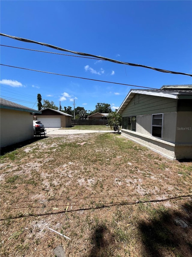 1708 28th St W, Bradenton, FL 34205 - view of yard featuring concrete driveway, a garage, and an outbuilding
