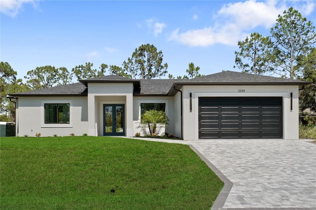 3344 Lagoy St, North Port, FL 34291 - prairie-style home with french doors, an attached garage, a front yard, decorative driveway, and stucco siding