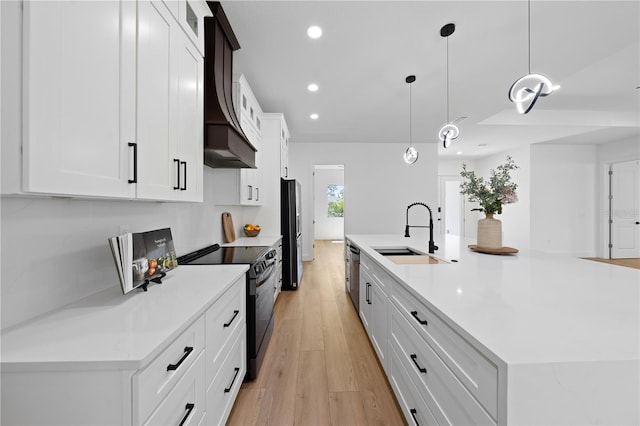 3344 Lagoy St, North Port, FL 34291 - kitchen featuring a sink, black electric range oven, freestanding refrigerator, light wood-style flooring, and a large island with sink