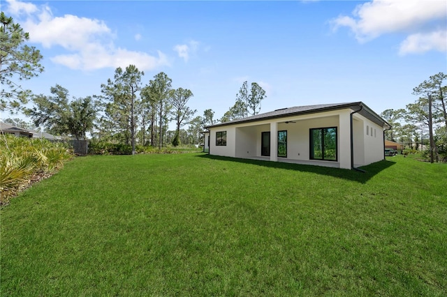 3344 Lagoy St, North Port, FL 34291 - rear view of property featuring a ceiling fan, stucco siding, and a yard
