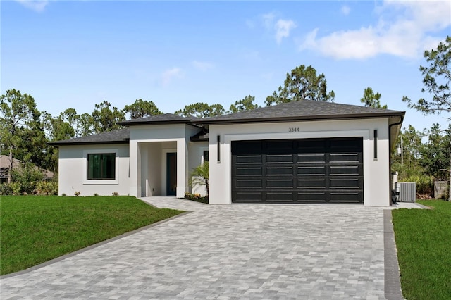 3344 Lagoy St, North Port, FL 34291 - view of front of home with an attached garage, central air condition unit, decorative driveway, and a front yard