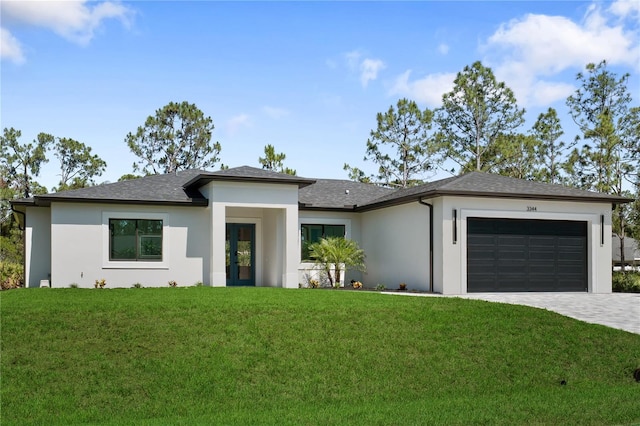 3344 Lagoy St, North Port, FL 34291 - prairie-style home featuring stucco siding, a garage, a front yard, decorative driveway, and a shingled roof