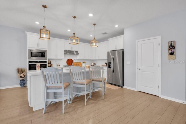 2781 Dolores Home Ave, Valrico, FL 33594 - kitchen with stainless steel appliances, light wood-type flooring, white cabinetry, light countertops, and recessed lighting