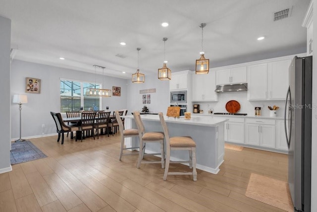 2781 Dolores Home Ave, Valrico, FL 33594 - kitchen with appliances with stainless steel finishes, under cabinet range hood, recessed lighting, white cabinets, and light countertops