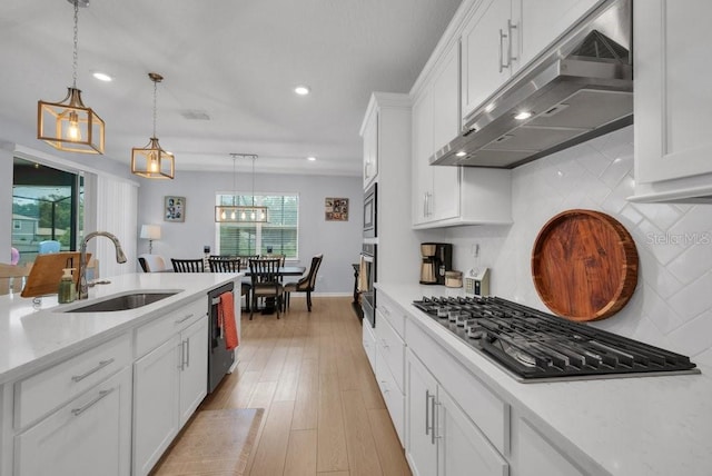 2781 Dolores Home Ave, Valrico, FL 33594 - kitchen with under cabinet range hood, stainless steel appliances, a sink, light countertops, and decorative backsplash