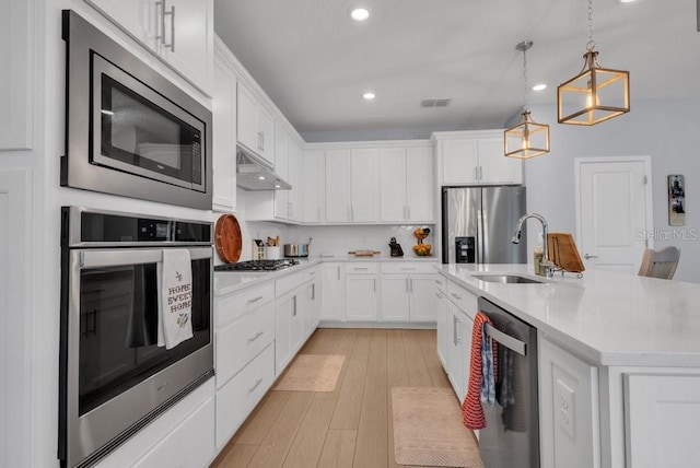 2781 Dolores Home Ave, Valrico, FL 33594 - kitchen with stainless steel appliances, under cabinet range hood, recessed lighting, white cabinetry, and light countertops
