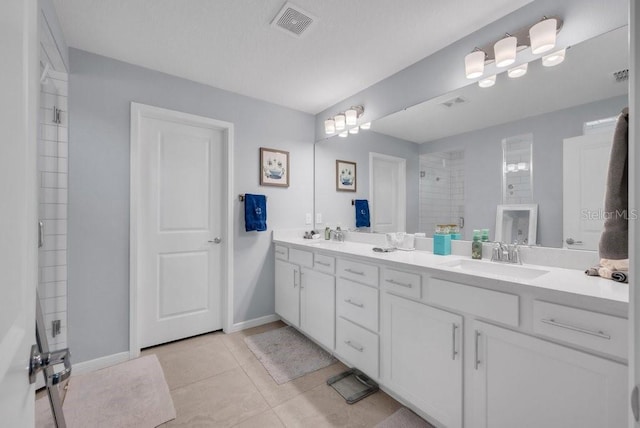 2781 Dolores Home Ave, Valrico, FL 33594 - bathroom with double vanity, a tile shower, baseboards, and tile patterned floors