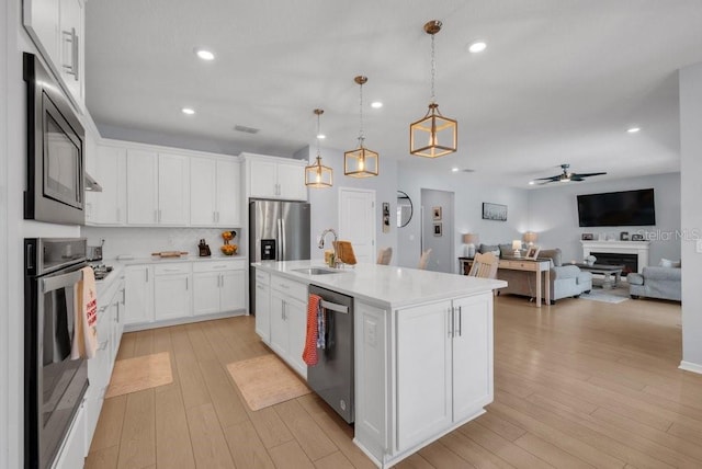 2781 Dolores Home Ave, Valrico, FL 33594 - kitchen with appliances with stainless steel finishes, light countertops, open floor plan, light wood-style flooring, and recessed lighting