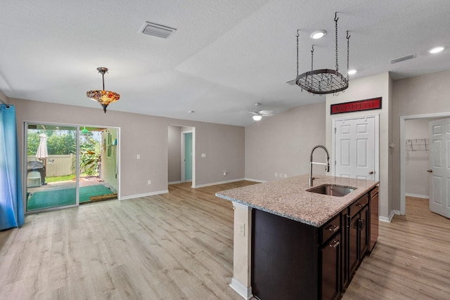 7302 Sunshine Bridge Ave, Gibsonton, FL 33534 - kitchen with light wood-type flooring, ceiling fan, decorative light fixtures, open floor plan, and light stone countertops