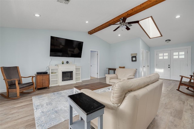 1913 Libby Ct, Holiday, FL 34690 - living area with light wood finished floors, a ceiling fan, a skylight, a glass covered fireplace, and recessed lighting